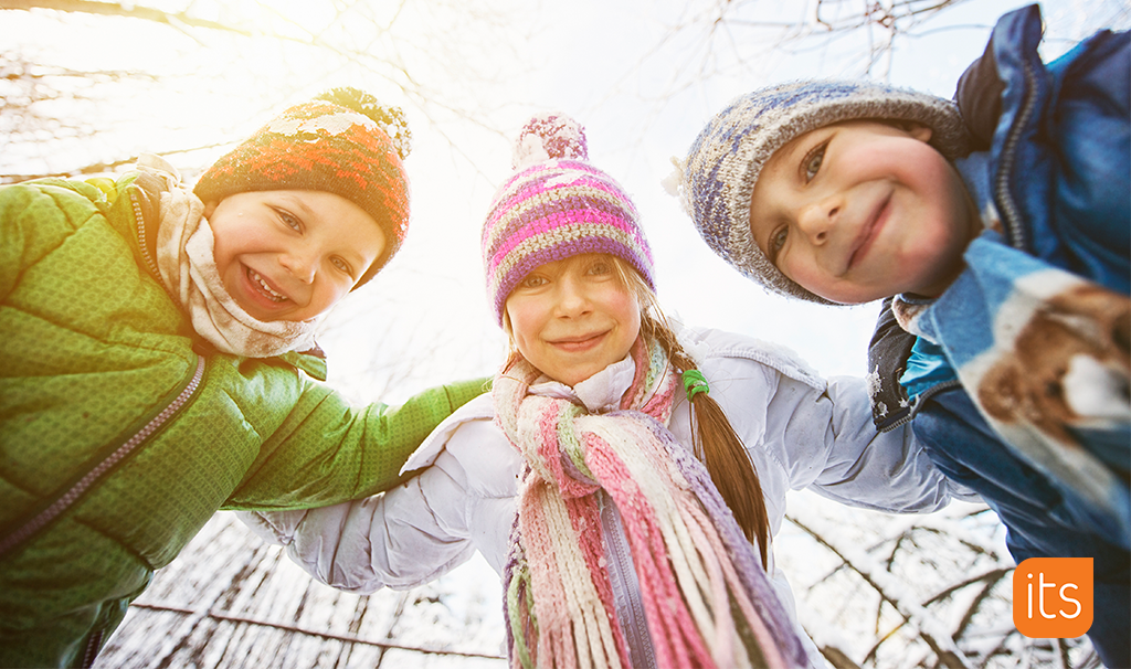 tre barn som smiler, ute i snøen